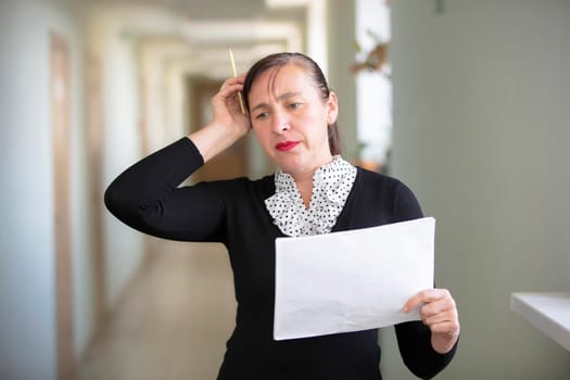 Woman at work with papers. The employee solves the problem.