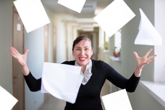 A woman in the office scatters papers. Nervous employee.