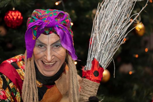 Baba Yaga with a broom on the background of the Christmas tree.Russian witch.