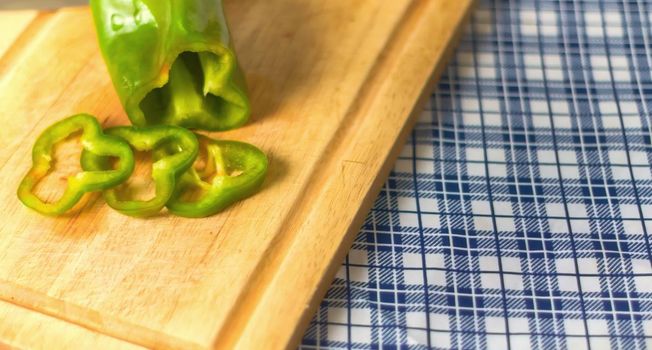Chopped bell pepper on a cutting board over a kitchen countertop.