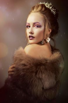 Luxurious girl with a beautiful make-up in a fur coat. Beauty in furs. Model on a bokeh background. Young beautiful woman.