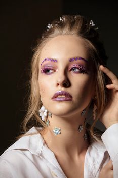Portrait of a model with bright makeup. Fashionable look. Beautiful girl with tanned skin.