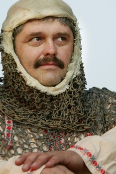 A man in the clothes of a medieval knight. Photograph of an ancient man.