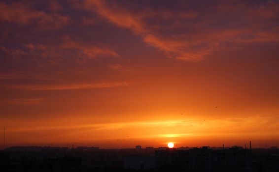 Red sunset over the city. Sunset. Red blue clouds at sunset. Panorama of the sunset.