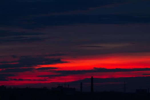 Red sunset over the city. Sunset. Red blue clouds at sunset.