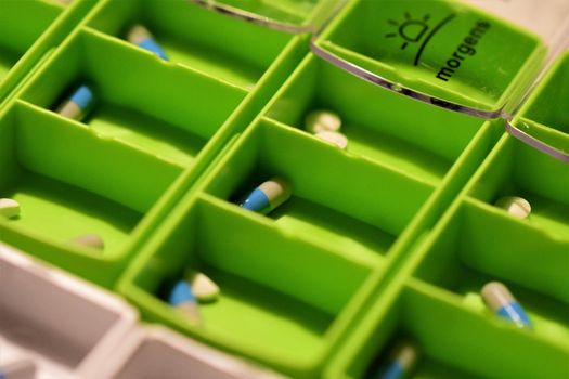 Close-up of different pills prepared in tablets boxes