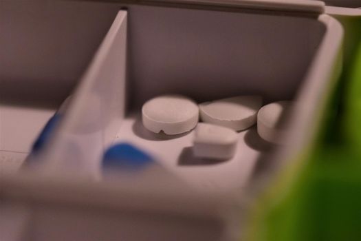 Close-up of different pills prepared in tablets boxes