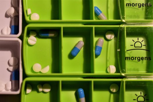 Close-up of different pills prepared in tablets boxes