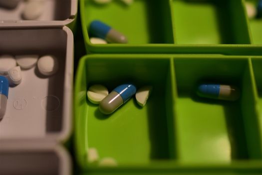 Close-up of different pills prepared in tablets boxes
