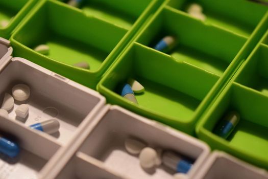 Close-up of different pills prepared in tablets boxes