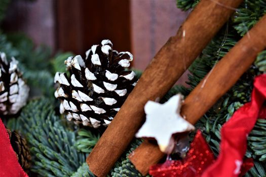 Fir branch with a pine cone and cinnamon sticks as a close up