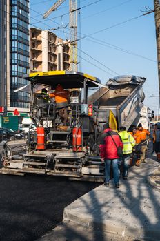 KYIV, UKRAINE - September 10, 2020: Industrial asphalt paver machine laying fresh asphalt on road construction site on the street