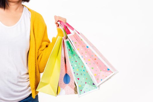 Happy woman hand she wears yellow shirt holding shopping bags multicolor, young female hold many packets within arms isolated on white background, Black Friday sale concept