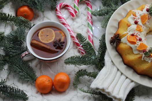 Tangerine pie with tea decorated with fir branches .Texture or background
