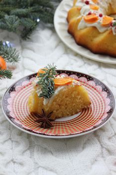 On the plate is a new year's dessert decorated with coniferous branches and tangerines