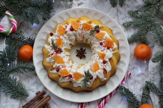 New year's cupcake is decorated with a slice of tangerine and a coniferous twig