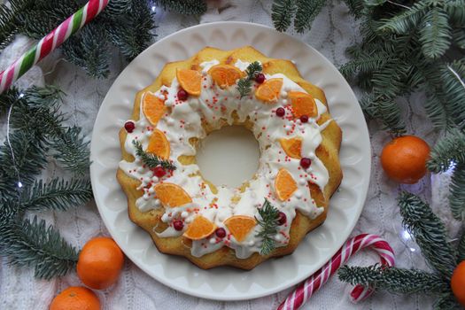 Close-up of a round cupcake decorated with a slice of tangerine and a pine twig