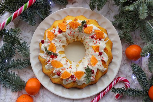 New year round cupcake with a Cup of tea decorated with tangerine slices and lollipops on the table