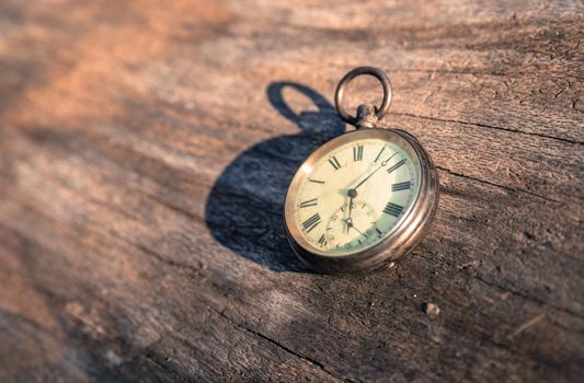 Vintage watch lies on a wood board, autumn time