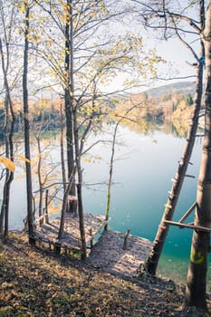 Autumn scenery: Footbridge and a blue lake, colourful laves