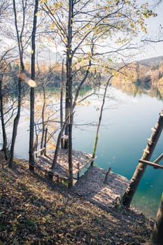 Autumn scenery: Footbridge and a blue lake, colourful laves