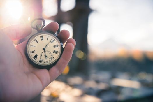 Hand held stop watch outdoors, autumn, blurry background