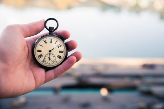 Hand held stop watch outdoors, autumn, blurry background