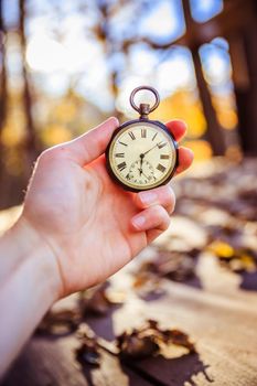 Hand held stop watch outdoors, autumn, blurry background