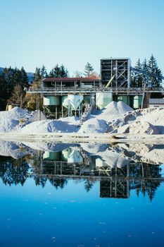 Blue lake in front of a gravel quarry, autumn time