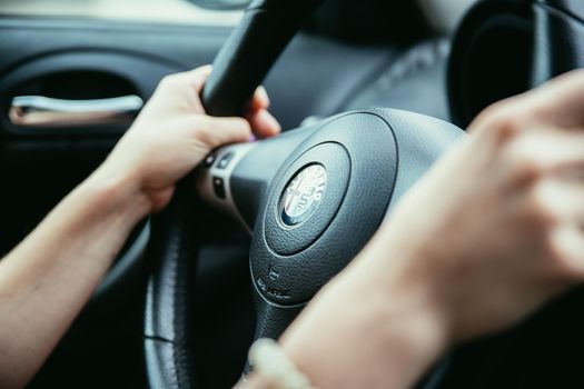 Female hands on a sports car steering wheel, car interior