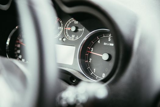 Dashboard of a sports car, steering wheel blurry