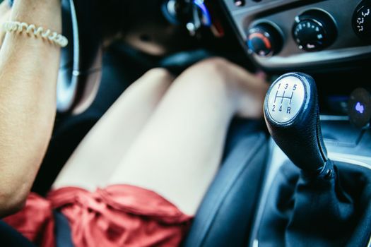 Naked legs of a young girl in a sporty car