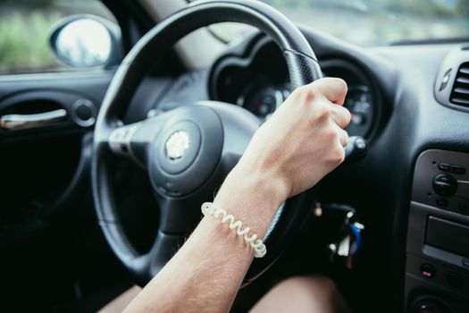 Female hands on a sports car steering wheel, car interior
