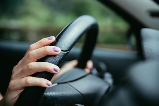 Sports car steering wheel, woman is driving