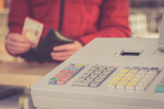 Cash register in a shop: Customer is paying purchase