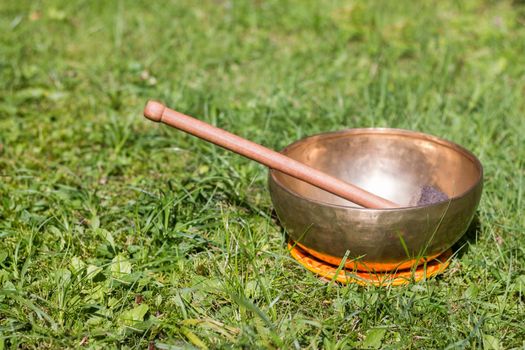 Metal singing bowls in the grass of the own garden, zen