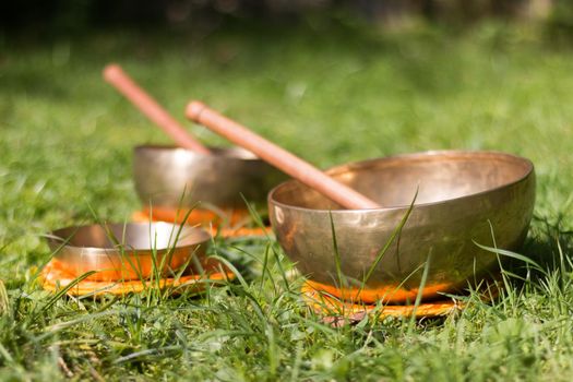 Set of metal singing bowls in the grass of the own garden, zen