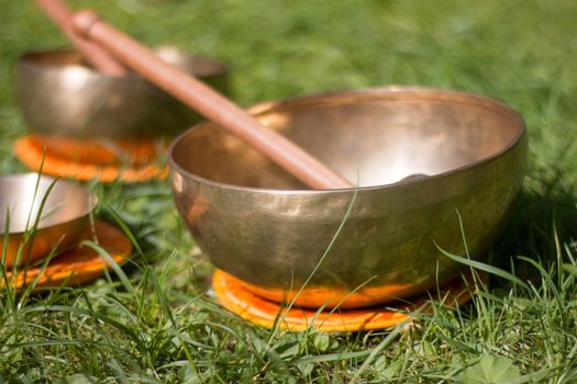 Set of metal singing bowls in the grass of the own garden, zen