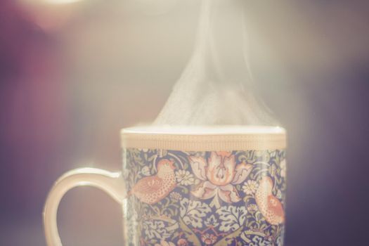 Steaming tea cup and sunlight, warm-up in winter