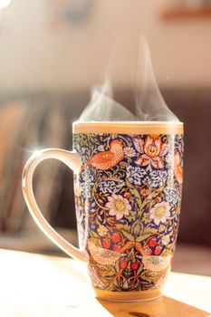 Steaming tea cup and sunlight, warm-up in winter