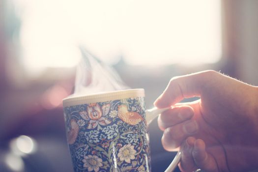 Steaming tea cup and sunlight, warm-up in winter