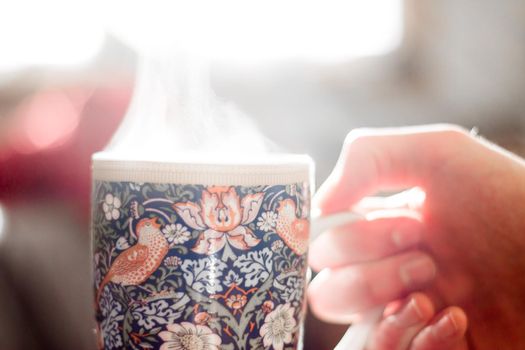 Steaming tea cup and sunlight, warm-up in winter