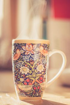 Steaming tea cup and sunlight, warm-up in winter