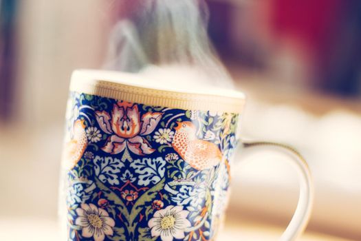 Steaming tea cup and sunlight, warm-up in winter