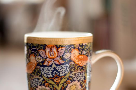 Steaming tea cup and sunlight, warm-up in winter