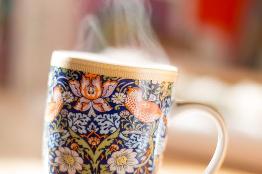 Steaming tea cup and sunlight, warm-up in winter