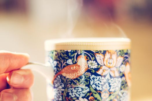Steaming tea cup and sunlight, warm-up in winter