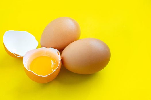 Closeup cracked brown eggs Buy from supermarket Placed on a yellow background.