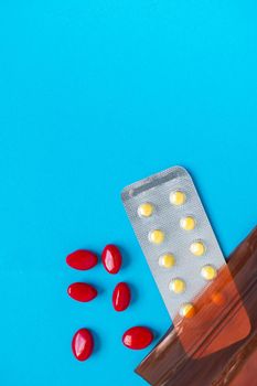 A pill that is poured out of the medicine bag There are many types of drugs used to treat various diseases. Blue background