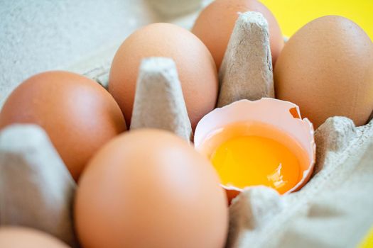 Closeup cracked brown eggs Arranged in a paper box Buy from supermarket Placed on a yellow background